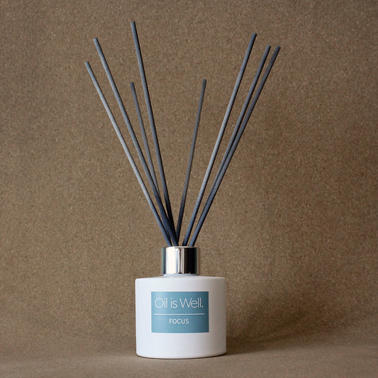 Oil Is Well Focus Reed Diffuser with dark grey reeds, designed for sustained mental focus, in an elegant white container.