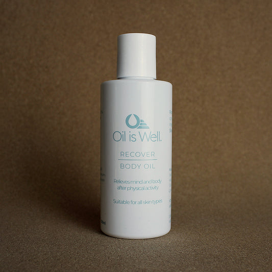 Oil Is Well Recover Body Oil, relieves mind and body post-activity, in a white minimalist bottle.